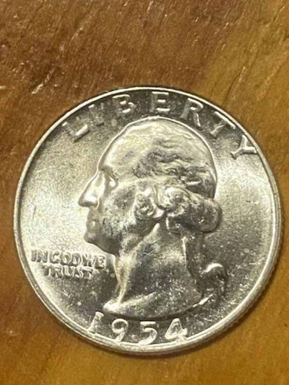1954年製クォーターコイン。ミントマークなし。表裏に染料エラーによるひび割れあり。未使用。