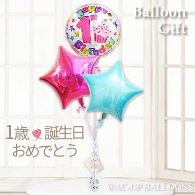はじめて迎える大切な記念日、1歳誕生日のお祝いにぴったりの華やかなバルーンギフト 「1」の数字バルーンと、可愛らしいケーキデザインのバルーンを組み合わせ、1歳のお誕生日らしさをしっかり演出できるバルーンブーケに仕上げました。 お部屋に飾るだけで、いつもの空間が一気に誕生日パーティー仕様に変わり、特別感あふれるお祝い空間を演出します。 1歳誕生日バルーンに加え、星型バルーンをバランスよくアレンジ。 ファーストバースデーの記念撮影や、誕生日会の飾り付けとしてもおすすめできるバルーンギフトです。 誕生日プレゼントとしてはもちろん、2人目・3人目のお子さまの1歳誕生日のお祝いにも多く選ばれています。 赤ちゃんだけでなく、お兄ちゃんやお姉ちゃんも一緒に楽しめるため、ご家族みんなの笑顔が広がる贈り物として密かな人気があります。 女の子・男の子どちらにも使いやすいデザインで、幅広いシーンに対応します。 お祝いの気持ちを形にして届けられるのも、バルーンギフトならではの魅力。 バルーン電報として贈れば、言葉だけでは伝えきれない「おめでとう」の気持ちを、見た目の華やかさとともにしっかり伝えることができます。 遠方に住むご家族やご友人への贈り物としても安心してご利用いただけます。 ふわふわと浮かぶバルーンは、赤ちゃんや小さなお子さまの興味を引きやすく、自然と笑顔があふれる楽しい時間を演出します。 ご自宅での誕生日パーティー、記念日の装飾、サプライズプレゼントなど、さまざまなシーンで活躍する1歳誕生日ギフトです。 心に残るファーストバースデーの思い出作りに、ぜひお役立てください。 高さ：　約140cm【卓上サイズ】 素材：アルミバルーン ※お使いのモニターの発色具合によって現物の色と異なる可能性があります。 【含まれるもの】 ・ヘリウムガス入りバルーン ・補充用ヘリウムガス1本（お届け時の調整用） ・無料メッセージカード ・ウエイト ・リボン あなたの想いをバルーンにのせて、バルーン電報を贈ってみませんか？ スタッフがひとつづつ心を込めて、お作りします。 当店は創業2000年、バルーン電報ギフト総合専門ショップです。 オールアバウトジャパンの「All Aboutスーパーおすすめサイト大賞」ギフト部門の受賞店です。