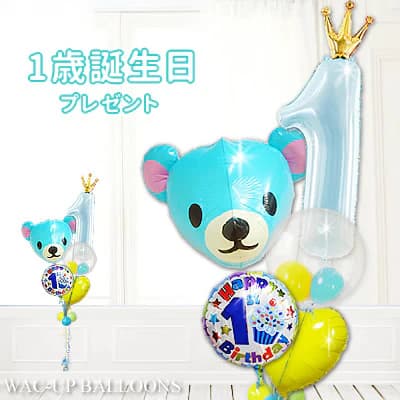 1歳という大切な節目のお祝いに、男の子にも喜ばれる1歳誕生日バルーンギフトです。 数字の「1」をモチーフにした存在感のある1歳型バルーンと、爽やかなブルーカラーが可愛いクマの「くーまブルー」を組み合わせたデザインは、ひと目で1歳誕生日だと分かり、初めてのお誕生日を華やかに演出します。 男の子へのプレゼントとしてはもちろん、ご家族やご親戚への贈り物としても選ばれている人気のバルーンギフトです。 箱を開けた瞬間、クマのバルーンと数字の「1」の形をしたバルーンがふわっと立ち上がるサプライズ演出で、「1歳の誕生日おめでとう」というお祝いの気持ちをしっかり届けることができます。 大きな数字「1歳」バルーンのトップには王冠モチーフをあしらい、1歳誕生日のお祝いにふさわしい特別感とおしゃれさをプラスしています。 ふわふわと浮かぶクマさんバルーンに、明るい黄色のハートバルーンを組み合わせることで、全体がより楽しく、元気な印象に仕上がっています。 1歳の男の子が思わず目を向けたくなる可愛らしさで、誕生日パーティーの主役を引き立ててくれるバルーンブーケです。 見た目の華やかさから、バルーン電報として贈っても印象に残りやすく、写真に収めたくなるギフトとして人気があります。 バルーンセットは、置いて飾るだけでお部屋が一気にお祝いムードに変わる手軽さも魅力。 特別な装飾を準備しなくても、1歳誕生日のお祝い空間を簡単に作ることができ、忙しいご家庭にもぴったりです。 自宅でのお誕生日会やお祝いの席を、明るく楽しい雰囲気に彩ります。 また、1歳誕生日の記念撮影にも大活躍。 数字の「1」がはっきり写るため、成長の節目をしっかり写真に残すことができます。 1歳誕生日のお祝い、男の子へのプレゼント、バルーン、お祝い、贈り物をお探しの方におすすめの1歳型バルーンギフトです。 バルーンブーケやバルーン電報としても喜ばれる、思い出に残るお祝いギフトをぜひお選びください。 高さ：　約230cm 素材：アルミバルーン ※お使いのモニターの発色具合によって現物の色と異なる可能性があります。 【含まれるもの】 ・ヘリウムガス入りバルーン ・補充用ヘリウムガス1本（お届け時の調整用） ・無料メッセージカード ・ウエイト ・リボン あなたの想いをバルーンにのせて、バルーン電報を贈ってみませんか？ スタッフがひとつづつ心を込めて、お作りします。 当店は創業2000年、バルーン電報ギフト総合専門ショップです。 オールアバウトジャパンの「All Aboutスーパーおすすめサイト大賞」ギフト部門の受賞店です。