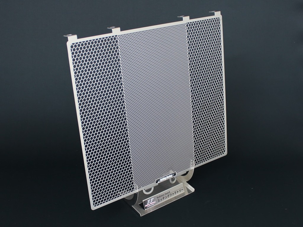 ■商品概要GPZ用KIT【付属品】エンブレムカラー：全色同梱(黒・赤・青・黄・緑)■詳細説明■なぜ必要か？'冷却効率'と'保護性能'という相反するテーマをいかにして両立させるか。フロントタイヤから巻き上げられた小石やゴミ、ライトめがけて飛んでくる昆虫...etcこれらはアルミのフィンでできているラジエターコアへダメージを与えます。フィンが潰されることによって冷却効果が失われ、場合によってはウォーターライン を破損しクーラント漏れを起こす危険も・・・■エッチングファクトリー製の特徴エッチングファクトリーのラジエターコアガードは、 ラジエターに対して最も過酷とも言える真夏の8時間耐久ロードレースを中心に幾度となくテストを繰り返してきました。メッシュパターンの配置、メッシュラインの太さ、そして開口率はレースシーンから のフィードバックがぎっしりと詰まっています。中央部分は細かく、両サイドは粗いヘキサゴンメッシュパターン。これはフロントタイヤからスピンオフされた小石やゴミをタイヤ幅に合わせた 中央部の細かいメッシュが 確実にガード。両サイドの粗いメッシュは'冷却効率'と'保護性能'という相反するテーマの両立を考慮 された開口率になっています。■材質の選択にも理由があります。アルミやチタンの場合、板厚を下げる(強度を下げる)ことでしか実現できない メッシュライン幅を、ステンレス(SUS3040.8t)を採用することにより理想のライン 幅で強度を下げずに実現。これらを踏まえたコアガードには、性能の維持するためのアイテムとしてだけではなく、さりげなく美しさをアピールするドレスアップ効果も兼ね備えました。守る、魅せる。あなたの大切なマシンの為に、自信を持っておすすめ致します。■エンブレムカラーは5色黒エンブレム青エンブレム緑エンブレム黄エンブレム赤エンブレムあなたのマシンのカラーに合わせたコーディネートを選択してください。■注意点※画像には他の商品が含まれている場合があります。※メーカー都合により商品の仕様変更がある場合がございます。ご了承ください。■適合車種GPZ&ensp;GPZ