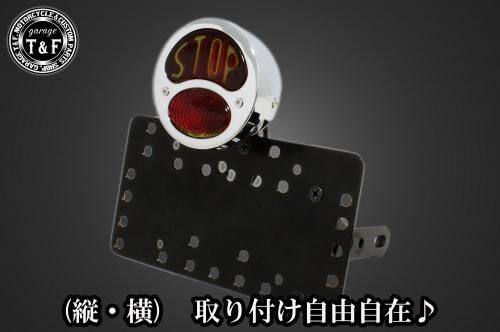 ■商品概要■本体の仕様素材：スチール製カラー：ブラック仕上げテールランプの仕様本体：スチール製色：メッキレンズ素材：ガラス製レンズカラー：レッド発光方法：ハロゲンバルブ(12v23wと12v5wの2連)レンズサイズ：約90mm(レンズ単体での計測)ナンバー灯：有り■テールランプ取り付けステーの仕様素材：スチール製配線の役割-上のバルブ-赤色：ブレーキランプ(＋)黒色：アース(-)-下のバルブ-赤色：ポジションランプ(＋)黒色：アース(-)■詳細説明クラシックなデザインと高性能を兼ね備えた「DUOテールランプ」。愛車に高級感と安全性をプラスする理想的なパーツです！-多様な取り付け方法-通常のサイドナンバーKITでは縦固定か横固定のみですが、本製品は縦横どちらにも対応。あなたのバイクスタイルに合わせた自由なレイアウトが可能です。-細かい調整機能-取り付けステーの角度調整や前後スライド調整が出来る為、ナンバープレートの位置を思い通りにセッティング可能。細部まで理想のスタイルを実現します。横向きの場合：7か所の取り付け位置を選択可能。縦向きの場合：12か所の取り付け位置を選択可能。-ボルトオンで簡単装着-車種専用のステー付きです。加工不要で取り付け可能。■注意点※製造ロットによってテールランプの配線の色、長さが変更されることがございますので予めご了承ください。※ガレージT＆FサイドナンバーKITは取り付け位置にかなり自由度がございます。しかしながらテールランプの種類によっては取り付け位置が制限される場合がございます。※ガレージ T＆FフラットフェンダーKITと同時装着する場合も取り付け位置が制限される場合がございます。※車種によっては、別売のサイドナンバーオフセットKITが必要となる場合がありますのでご注意ください。※メーカー都合により商品の仕様変更がある場合がございます。ご了承ください。■適合車種W230&ensp;W230メグロS1&ensp;メグロS1