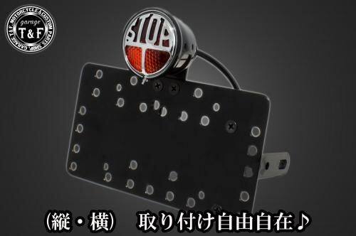 ■商品概要■本体の仕様素材：スチール製カラー：ブラック仕上げテールランプの仕様本体：スチール製色：ブラックレンズ素材：プラスチック製レンズカラー：レッド発光方法：ハロゲンバルブ(12v-21／5w)レンズサイズ：64mmナンバー灯：有り■テールランプ取り付けステーの仕様素材：スチール製■配線の役割赤色：ブレーキランプ(＋)青色：ポジションランプ(＋)黒色：アース(-)■詳細説明テールランプ中央に大きく刻まれた「STOP」の文字が特徴的。クラシックなデザインが後方車両に視認性とインパクトを与えます。-多様な取り付け方法-通常のサイドナンバーKITでは縦固定か横固定のみですが、本製品は縦横どちらにも対応。あなたのバイクスタイルに合わせた自由なレイアウトが可能です。-細かい調整機能-取り付けステーの角度調整や前後スライド調整が出来る為、ナンバープレートの位置を思い通りにセッティング可能。細部まで理想のスタイルを実現します。横向きの場合：7か所の取り付け位置を選択可能。縦向きの場合：12か所の取り付け位置を選択可能。-ボルトオンで簡単装着-車種専用のステー付きです。加工不要で取り付け可能。■注意点※製造ロットによってテールランプの配線の色、長さが変更されることがございますので予めご了承ください。※ガレージT＆FサイドナンバーKITは取り付け位置にかなり自由度がございます。しかしながらテールランプの種類によっては取り付け位置が制限される場合がございます。※ガレージ T＆FフラットフェンダーKITと同時装着する場合も取り付け位置が制限される場合がございます。※車種によっては、別売のサイドナンバーオフセットKITが必要となる場合がありますのでご注意ください。※メーカー都合により商品の仕様変更がある場合がございます。ご了承ください。■適合車種W230&ensp;W230メグロS1&ensp;メグロS1