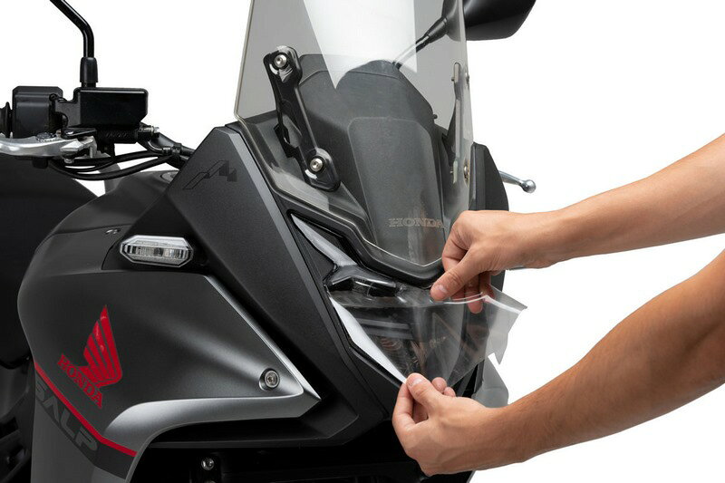 適合車種: HondaXL750 Transalp (2023-2024)Article No: 21659WEAN: 8435529353412Protect your motorcycle's headlight from minor impacts and scratches without affecting the aesthetics.The new line of Adhere headlight protectors from Puig Hi Tech Parts provides effective protection of the headlight against the impact of small objects scratches dirt insects and premature wear due to exposure to UV rays.It is made of a high-end 200 micron thick totally clear polyurethane sheet. Therefore it remains unnoticed when installed on the motorcycle without affecting the aesthetics and guaranteeing optimal lighting.The Adhere invisible protector is designed specifically for each motorcycle model guaranteeing a perfect fit across the entire surface of the headlight regardless of its shapes and without the need to install supports.It is useful for all types of motorcycles but especially for Trail models since they are more likely to be hit by small loose stones on the road that would damage the headlight.It can be installed and uninstalled easily and quickly without leaving any type of mark it does not scratch or come off when washed or inclement weather.SUITABLE ALSO FOR: +HONDA XL750 TRANSALP (2023 2024)