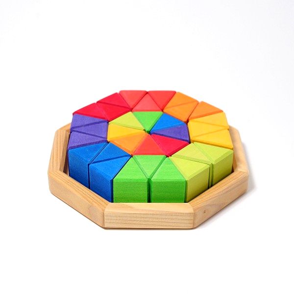 厚みのある二等辺三角形が8色それぞれ4つずつの計32個のセットです。平面のモザイク遊びの中で、「同じ色どうしを集めると大きな二等辺三角形ができる」、「他の色も含めて作ると、さらに大きな三角ができる」など、遊びながら形の面白さに気付かせてくれます。木箱に片づけると正八角形になる点も発見のひとつです。 商品名 にじのオクタゴン・小 メーカー ドイツ／グリムス社 サイズ・内容 木枠：20 × 20 cm ブロック基尺：4 × 3.3 × 4.2 cm 全32ピース 木箱入り 材質 シナの木 【木のおもちゃ 積み木 つみき 積木 木製玩具 知育玩具 出産祝い お誕生日】「虹色の配色」が代表的なグリムス社 グリムスの木のおもちゃは、シンプルなものばかりで、 子供が自分のアイデアで自由に遊べる創造性を豊かにしてくれます。 積み木として遊んだり、平面に並べて模様と描いたり、クルマの道やトンネル・・・ いろんな遊びへと広がっていきます。 遊びやすさの特徴 グリムス社の積み木のほとんどが「シナの木」を使用しています。木材としては軽い素材に分類され、積み木の大きさのわりには軽い印象を受けます。 もうひとつの特徴は、積み木のザラザラとした質感にあります。 手に取るととても温かみがあり、手触り感が良いです。積み木の表面が滑らかなものと比べて、積み木が滑りにくいので積みやすく、倒れにくいので、子供が遊びやすい積み木です。 斜めに積むといったちょっと難しい積み方も簡単にできますよ。 安全性 グリムス社製品の塗料は全て無害無毒なものを使用しています。 ヨーロッパの玩具安全基準を満たしています。