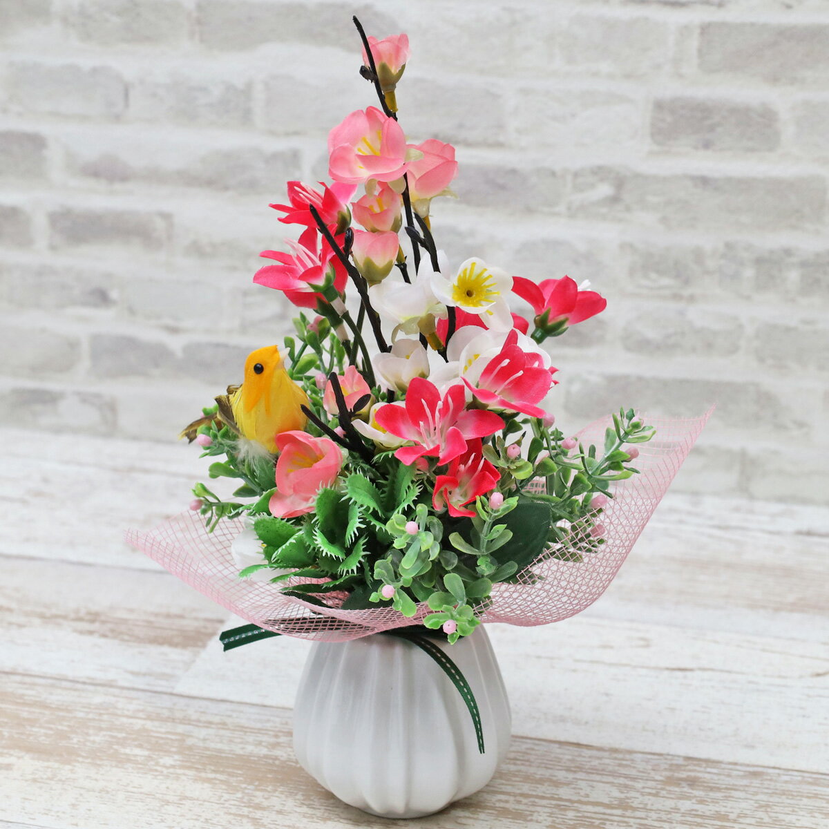 鮮やかな梅の花と可愛らしい黄色の小鳥が印象的なアレンジです。サイズ：約高さ25cm×幅16cm×奥行14cm＊商品の仕様は変更になる場合がございます＊受注制作のため数日お時間をいただく場合がございます シルクフラワーとは、シルクの様な光沢の...