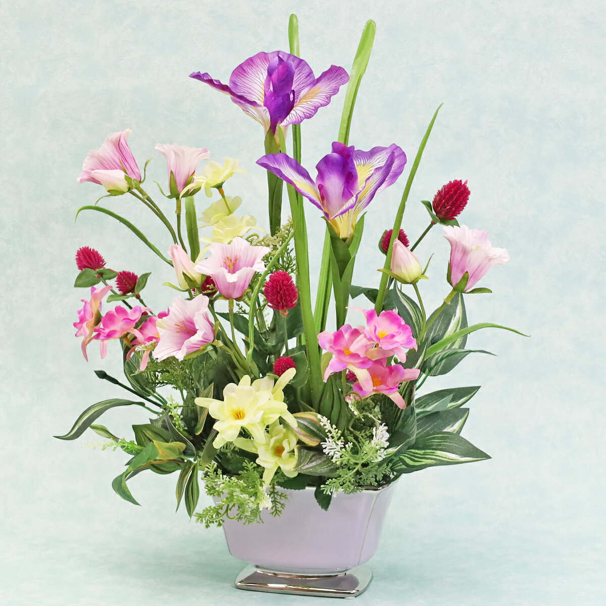 落ち着いた紫の花器に可愛らしいおだまきやシックなアヤメを使用したアレンジです。サイズ：約高さ42cm×幅35cm×奥行18cm＊商品の仕様は変更になる場合がございます＊受注制作のため数日お時間をいただく場合がございます シルクフラワーとは、シルクの様な光沢のある生地を用いて作られ、 生花のような花びらのグラデーション・葉や茎の樹皮や節までリアルを追求した高品質な人工的な花のことをいいます。 他にも、一般的な造花を指すアートフラワーと呼ばれることもあります。 また、近年では呼び名が統一され、生花の代わりとなる人口的な花のことを全てまとめてアーティフィシャルフラワーと呼ばれる様になりました。 ☆ギフト対応の詳細はこちら シルクフラワーのグレードアップアイテム♪ お部屋の防臭・防汚抗菌作用も CT触媒リキッド200mlボトル 初めての方専用是非お試しください お任せグリーンアレンジ 1本でアレンジ約1つ分お試しサイズ50ml CT触媒リキッド50mlボトル