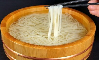 商品説明 商品名 贈答細麺冷やしたらいうどん 名称 細麺うどん・つゆセット 原 材 料 うどん　　小麦粉・食塩・醸造酢・加工澱粉 　　　　 　 粗製海水塩化マグネシウム（にがり） つゆ　 　 醤油（小麦を含む）・味醂・砂糖・食塩・酢 　　　 　　 風味原料（さば・うるめ・鰹・昆布・干し椎茸） 　　わかめ　 わかめ・塩 内 容 量 細麺うどん（300g)×3袋・ざるつゆ（100cc)×9袋・生わかめ（300g）×1袋 保存方法 うどん　　直射日光を避け、常温で保存（暗所） つゆ　　　冷暗所で保存（開封後要冷蔵） わかめ　 冷暗所にて保存（20℃以下） 賞味期限 うどん：約4ヶ月 つゆ　：約4ヶ月　　　　　 わかめ：約1年　　細 麺 冷 や し た ら い う ど ん (9食) わ か め 付 ※写真はイメージです。 ＼ 贈り物にオススメは桶付き ／ こちらからどうぞ！ 他にもご準備しております！ ご家族人数や用途に合わせてお選びください☆ -3食- -6食（わかめ付）- 山のせが目指すうどんは、ソフトな弾力と喉越しの良い食感です。 それらを表現するために必要な小麦を創業以来厳選し続けています。土三寒六常五杯とよく言われますが、うどんの麺はコントロールしなければ一定の品質の物は作れません。 熱いと柔らかくなり生地はダレた状態になりやすく、寒いと硬くなりすぎてしまいます。 そこで夏は食塩の量を多くして生地を絞め、冬は食塩の量を減らして生地が硬くならないようにするわけですが、 塩を溶く水の量を変えることで小麦粉への加水量も調節し、いつでも美味しいうどんを作っています。 「混ぜ物のない小麦の薫るうどん」がたらいを「泳ぐ」まで、私たちは徹底した管理のもと、美味しいうどんを作り続けます。 30年間の歴史の中でお客様の味覚に合うだしになるまで、試行錯誤を続けてきました。素材集めからだしを取るまでの1つ1つの工程を自分たちで行うことにより、山のせの味を作り出しています。 素材は毎年厳選し、その30余年の歴史の中で味を表現できるものを選びます。 また素材だけではなく、調味料の選定にも気を配っています。 通常の醤油は、発酵を早めるためのアミノ酸などを使用しているので、山のせでは本醸造醤油を使用しています。 本醸造醤油は長い時間をかけ大豆のみで発酵、抽出したものです。使われている調味料の素材にまで目を向けることにより、本当に安心してお食事頂ける環境を作っています。 だし抽出の工程では、厳選素材の相乗効果による味や、香り、うま味の引き出し方を研究し、より美味しいものをお客様にお届けいたします。