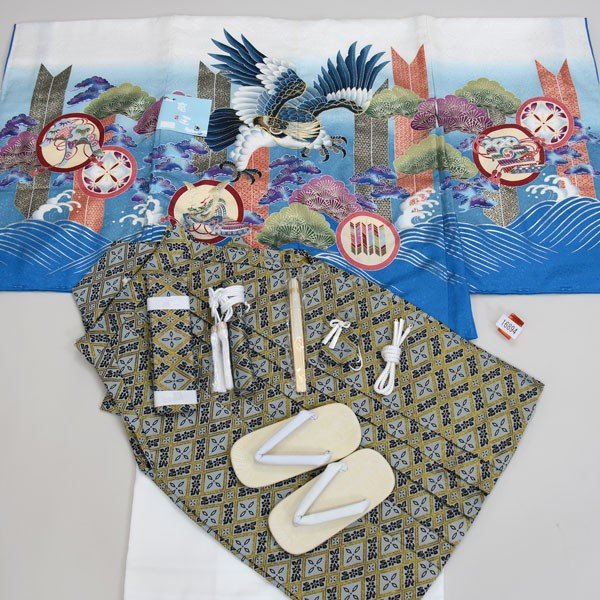 項目 五歳羽織袴フルセット ・羽織 ・着物 ・長襦袢 ・袴 ・草履 ・角帯 ・扇子 ・短剣 ・羽織紐 ・お守り 品質 すべて新品　仕立て上がり（すぐ着用できます） ※既製品ですが、上げはとられていないので、一般的な三歳〜五歳サイズですとお直し（肩上げ腰上げ）が必要です ★金糸で彩られた豪華な柄がキラリと光る祝着です。 綺麗な染料で彩られとても見栄えが良いです♪ ★羽織、着物、袴の表地に高質ポリエステルを使用 ・高質ポリエステルの特徴 1.正絹と比べても見劣りしません。 （むしろ低質な正絹よりも高質ポリエステルの方が、見栄えが断然良いです。） ※ポリエステルより正絹が良い品質とされたのは、昔のこと。 近年の合繊技術向上により、ほとんど見劣ることがございません。 2.合繊であるため正絹と比べて保存状態が良く、長い時間を経ても状態が変化しにくいです。 3.万一、汚れても洗うことができます。 その場合は、クリーニングに出すことをお勧めいたしますが、正絹より安価で取り扱っていただけます。 ★豪華で品質高い紋袴 羽織、着物、長襦袢、袴→表裏地ともに高質ポリエステル100％ 草履→合皮素材 サイズ ■羽織丈約65cm 裄丈約55cm 袖丈約57cm 着物丈約105cm 袴丈約60cm 適合身長95cm〜125cm ■草履18cm（フリーサイズ） ※着丈＝背中首のゴリゴリ部分から、足くるぶしまでの長さ ※裄丈＝腕を斜め45度下げた状態で、背中首ゴリゴリ部分から、肩上を通して、手くるぶしまでの長さ 仕立て 上記サイズにて合う場合はこのままでもご着用できますが、お子様の身長にあわせて無料でお直し承ります。 5日間ほどで、お仕立て可能です。 ※一般的に3歳、5歳のお子様は、お仕立て（お直し）が必要です。 1．お仕立て（肩上げ）のみ身長108cm以上～推奨 ※おはしょりの簡単な着付けができる場合はこちらを推奨します。 2．お仕立て（肩上げ、腰上げ、羽織丈上げ全て）身長95cm以上～推奨　　 ※お子様の身長が106cm以下の場合はこちらを推奨します。 106cm以上でも着付けを容易にする場合は全てお直しを推奨します。 ご希望のお客様は「お子様の身長」をご連絡ください。 最適寸法を連絡後、お直しいたします。 ※お仕立て（直し）は国内の縫製所（プロの縫い子）に依頼してます。 ※羽織、着物、長襦袢いずれも丈直し承ります。 2をご選択頂いた場合は全てお直し致します。 ※ご要望の場合は、プルダウンメニューから選択できます。 紋入れ 半衿 足袋 腰紐 草履の交換 袴変更可能 着付け説明書 ■家紋は別途￥6600で入れることができます。（五つ紋を入れます） ご要望の方は家紋名をお知らせください。6〜8日間のお時間をいただきます。 ※紋は、染め紋（摺り込み紋）になります。 ※注文フォームの備考欄に『家紋の種類』をご明記ください。 又は、「メール（aji_net@khaki.plala.or.jp）」「お電話」どちらでも結構ですので、ご連絡ください。 (家紋名が分からない場合は、家紋の画像を添付ファイル又はFAXでお送りください。) ■半衿は別途ちりめん地￥1000又は無地￥500でご用意することができます。 ・半衿をご要望でお仕立て（肩上げ、腰上げ）を依頼されている場合、工賃無償で長襦袢に半襟縫いつけさせていただきます。 ・お仕立て（肩上げ、腰上げ）を依頼されなくとも、半衿縫い付けのみも工賃￥680で承ります。 ・お客様ご自身で縫われる場合は、以下サイトをご参考ください。 https://item.rakuten.co.jp/yasudaya589/c/0000000130/ ■足袋は2種類からご用意できます。 1．ソックスタイプの足袋：別途￥580 17〜18cm、19〜20cm 2．こはぜ付本格足袋（日本製）：別途￥1500 17〜18cm、19〜20cm ■男児用腰紐1本：別途￥240 ■草履は、16.5cmもしくは19cmに変更することができます。 ※草履は、靴と異なり、足のサイズにあわせる必要はございません。 草履サイズより0.5cm程度大きくても着用できます。 ■袴の変更が可能です。 ■ご希望であれば「着付け」の説明書をお付けいたしております。（無料） ※ご要望の場合は、「買い物かごに入れる」ボタンの上、プルダウンメニューから選択できます。ご注文内容確認後、当店より合計金額をメールにてお知らせ致します。 お客様の声 安田屋ではお客様の声を強く反映しております。 ご購入されたお客様の声をご参考ください お客様の声リンク 返品 もしも見た目と違ってたら・・・、思ってたものと違ってたら・・・・。 そんな場合がありましたら、ご返品を承ります。 ※その際には、送料のみご負担ください。（元払いでご返送いただければ、結構でざいます。） ※返品は未仕立てに限ります。 ※ご返品の際には、商品到着後8日以内にご連絡ください。 在庫 当店で出品されている商品はほとんど同一商品の在庫を持ちあわせておりませんので、ご注意ください。 また、当店は実店舗が存在しております。 基本的に出品中の商品を実店舗に来られたお客様がご購入された場合は、直ちに楽天から取り下げておりますが、 取り下げる前にご購入されてしまった場合、その商品をお届けできない場合がありますのでご了承ください。