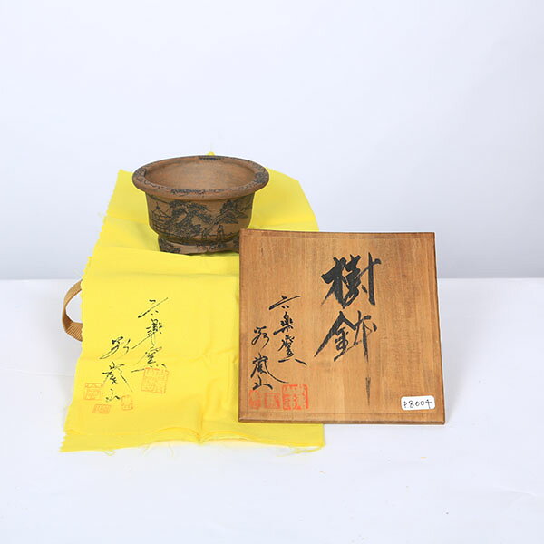商品説明 谷嵐山　外縁段足丸鉢 1940年　埼玉県出身。 本名　谷弘行 陶号　六楽嵐山 本業は寿司職人だったが、趣味の盆栽が高じて作陶。 昭和54年（1979年）に仲間6人と共同窯【六楽窯】を築く。 谷氏の作品は籠目文様などの緻密な浮彫を使用した秀品が多く、寿司店を廃業以降は郷里（花園町）で活発な作陶活動を行っておられます。 国産鉢 『共布・木箱付』 サイズ 鉢径：約9.2cm　高さ：約5.2cm 納期配達ご希望日時のご指定ができます。 お急ぎの場合は午前中までにご注文の場合、即日発送も可能です。 配送【配送業者】 ヤマト運輸【配送サービス名】宅急便