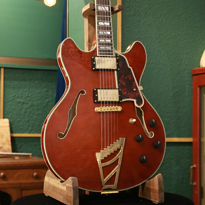 ＝＝＝＝＝＝＝＝＝＝＝＝＝＝＝＝＝＝ この商品はアウトレット・モデルです。 アウトレット・モデルとは、キズ、塗装むら、パーツに錆びやくもりなどがある商品のことを意味します。 従って、これらに起因する修理につきましては、お客様のご要望により有償修理とさせていただきます。 但し、楽器本来の性能やサウンドにつきましては特に問題のない商品ですので、 その他の修理(例：「音が出なくなった」「音がつまる」等)につきましては、保証規定に従いまして修理させていただきます。 ＝＝＝＝＝＝＝＝＝＝＝＝＝＝＝＝＝＝ 16インチ(406.4mm)幅、1.75インチ(44.45mm)厚のオリジナル・ダブル・カッタウェイ・シェイプにセンター・ブロック構造をもったセミホロー・ボディーに、ステアーステップ・トラピーズ・テイルピースを搭載したExcel DC Stairstepは、ディアンジェリコらしさを感じるオリジナル形状のピックガードは、fホールの一部を思わせるデザインで、トータス・シェル柄(5プライ)となっています。 ボディー・トップ、ヘッドストックとネックにはバインディングが装飾され、マザー・オブ・パール/アバロンの存在感のあるスプリット・ブロック・ポジションマーカーと組み合わせたデザインはシックでゴージャスな印象を与えます。 ボディー・マテリアルはトップ、サイド&バック共にフレイム・メイプルとなっています。 メイプル/ウォールナット/メイプルのネックには、ローズウッド・フィンガーボードを用いています。 24.75インチ(628.65mm)のスケールを採用し、ネックはメイプルの間にウォールナットを挟んだ反りや捻じれに強い3ピース構造です。 また、ネック・ジョイントはセット・ネック・ジョイントとなっています。さらに、デュアル・アクションのトラスロッドを搭載し、ヘッド側で調整するようになっています。 特徴的なヘッドストック・デザインはディアンジェリコの伝統を継承しています。 トラスロッド・カバーはアルミニウム製で、1930年頃にニューヨークで流行したアール・デコ建築(エンパイア・ステート・ビルディングなど)が建ち並ぶニューヨークの摩天楼にインスパイアされた存在感のあるデザインです。 ピックアップは、メタル・カバードのUSAセイモア・ダンカンの59ハムバッカーを搭載しています。 コントロールは2ヴォリューム、2トーン、3ウェイ・ピックアップ・セレクターのレイアウトで、各ピックアップのトーンはコイル・スプリットのプッシュ・プル・スイッチを兼ねており、トータルで8通りのコイルの組み合わせを備えています。 ハードウェアはゴールドで統一し、信頼性の高いグローバーのインペリアル・マシンヘッド、ステアーステップ・トラピーズ・テイルピース&チューンOマティック・ブリッジの仕様です。 カラーは、グロス・フィニッシュで美しい杢目を生かしたヴィオラです。 頑丈な専用ハードケースが付属します。 SPEC ■Headstock Shape: Standard ■Headstock Logo Inlay: Mother of Pearl D'Angelico New York Logo ■Headstock Series Inlay (Front): Mother of Pearl Excel Shield Logo ■Serial Number (Back): Model Name, Serial Number ■Headstock Binding: 3-Ply ■Headstock Finish: Gloss ■Headpin: Cupola ■Tuners: Grover® Imperial ■Strings: Nickel Round Wound.010-.046 ■Truss Rod Cover: Aluminum Skyscraper ■Nut Width: 1 11/16" (42.86mm) ■Fingerboard Material: Rosewood ■Fingerboard Binding: 3-Ply ■Fretwire: Jescar 47/104 Nickel Silver ■Scale Length: 24.75" (628.65mm) ■Fingerboard Radius: 16" (406.4mm) ■Top Inlay: Mother of Pearl/Abalone Split-Block ■Fret Number: 22 ■Neck Material: 3 Piece ■Neck Finish: Gloss ■Neck Profile: C-Shape ■Joint Type: Set Neck ■Truss Rod: Dual Action ■Body Shape: Double Cutaway ■Body Style: Semi-hollow (with Centerblock) ■Body Depth: 1.75" (44.45mm) ■Body Width: 16" (406.4mm) ■Body Color: Viola ■Body Finish: Gloss ■Body Top Material: Laminated Flame Maple ■Body Back Material: Laminated Flame Maple ■Body Side Material: Laminated Flame Maple ■Body Binding: 5-Ply ■Bridge: Gold Tune-O-Matic ■Tailpiece: D'Angelico Stairstep ■Pickguard: Tortoise Scalini (5 Ply) ■Pickup Selector: 3-Way Toggle ■Knobs: 4 Ebony ■Strap Buttons: Gold, Locking ■Electronics Overview: 2 Humbuckers / 2 Volume / 2 Tone (Push / Pull) / 3-Way Toggle Switch ■Pickup (Neck): USA Seymour Duncan® 59 Humbucker (Gold Cover) ■Pickup (Bridge): USA Seymour Duncan® 59 Humbucker (Gold Cover) ■Pots: 500k ■Output Jack: Standard Mono ■Hardware Color: Gold ■Case: Deluxe Hardshell