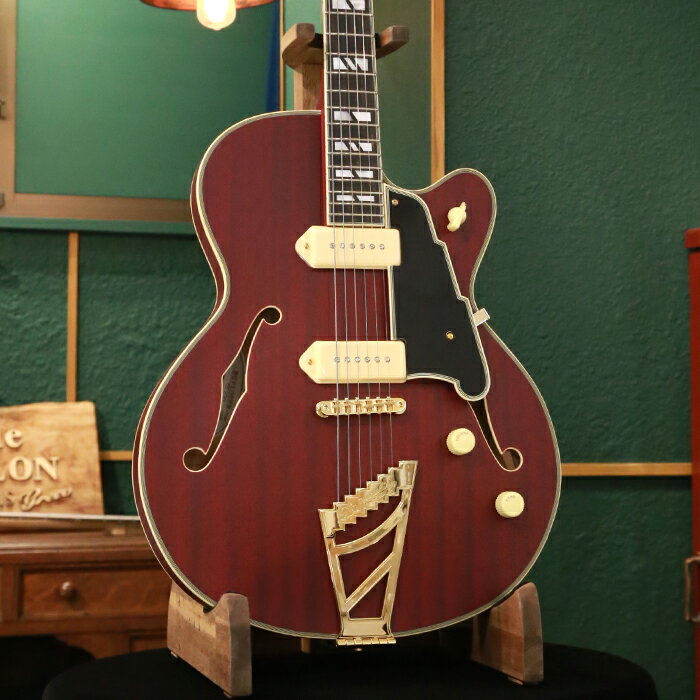 ＝＝＝＝＝＝＝＝＝＝＝＝＝＝＝＝＝＝ この商品はアウトレット・モデルです。 アウトレット・モデルとは、キズ、塗装むら、パーツに錆びやくもりなどがある商品のことを意味します。 従って、これらに起因する修理につきましては、お客様のご要望により有償修理とさせていただきます。 但し、楽器本来の性能やサウンドにつきましては特に問題のない商品ですので、 その他の修理(例：「音が出なくなった」「音がつまる」等)につきましては、保証規定に従いまして修理させていただきます。 ＝＝＝＝＝＝＝＝＝＝＝＝＝＝＝＝＝＝ オリジナルの16インチ幅、1.75インチ厚のシングル・カッタウェイ・シェイプのホロー・ボディーのモデルのDeluxe 59は、ディアンジェリコらしさを感じるオリジナル形状のピックガードは、fホールの一部を思わせるデザインで、5プライのブラックとなっています。 ボディー・トップ、ヘッドストックとネックにはバインディングが装飾され、マザー・オブ・パールの存在感のあるスプリット・ブロック・ポジションマーカーと組み合わせたデザインはシックでゴージャスな印象を与えます。 ボディー・マテリアルはトップ、サイド&バック共に同じ材で統一し、マホガニーを使用しています。 ネックはメイプルの間にウォールナットを挟んだ反りや捻じれに強い3ピース構造で25インチのスケールを採用し、エボニー・フィンガーボードを用いています。 ネックとボディーの接合はセット・ネック・ジョイントで、デュアル・アクションのトラスロッドを搭載し、ヘッド側で調整するようになっています。 特徴的なヘッドストック・デザインはディアンジェリコの伝統を継承しています。 トラスロッド・カバーは高級感のあるエボニー製で、1930年頃にニューヨークで流行したアール・デコ建築(エンパイア・ステート・ビルディングなど)が建ち並ぶニューヨークの摩天楼にインスパイアされたデザインです。 ピックアップは、セイモア・ダンカンのディアンジェリコ・グレート・デーンP90を2基搭載しています。 コントロールは1ヴォリューム、1トーンで、3ウェイ・ピックアップ・セレクター・スイッチを採用しています。 また、カップケーキ・コントロール・ノブやチキンヘッド・スイッチ・ノブはクラシックなルックスを演出しています。 ハードウェアはゴールドで統一し、信頼性の高いグローバーのスーパー・ロトマティック・ロッキング・マシンヘッド、チューンOマティック&ステアー・ステップ・テイルピースの仕様です。 カラーは、サテン・トランス・ワインです。 頑丈な専用ハードケースが付属します。 SPEC ■Headstock Shape: Standard ■Headstock Logo Inlay: Mother of Pearl D'Angelico New York Logo ■Headstock Series Inlay (Front): Mother of Pearl Deluxe Shield Logo ■Headstock Serial Number (Back): Model Name, Serial Number ■Headstock Binding: 3-Ply ■Headstock Finish: Satin ■Headpin: Cupola ■Tuners: Grover 509 Super Rotomatic, Locking ■Strings: 10-46 ■Truss Rod Cover: Skyscraper, Ebony Wood ■Nut Width: 1 11/16" (42.86mm) ■Nut Material: Bone ■Fingerboard Material: Ebony ■Fingerboard Binding: 3-Ply ■Fretwire: Jescar 47/104 Nickel Silver ■Scale Length: 25" (635mm) ■Fingerboard Radius: 12" (304.8mm) ■Fingerboard Top Inlay: Mother of Pearl Split Block ■Fret Number: 22 ■Neck Material: 3 Piece: Maple / Walnut / Maple ■Neck Finish: Satin ■Neck Profile: C-Shape ■Joint Type: Set Neck ■Truss Rod: Dual Action ■Body Shape: Single Cutaway ■Body Style: Hollowbody ■Body Depth: 1.75" (44.45mm) ■Body Width: 16" (406.4mm) ■Body Color: Satin Trans Wine ■Body Finish: Satin ■Body Top Material: Laminated Mahogany ■Body Back Material: Laminated Mahogany ■Body Side Material: Laminated Mahogany ■Body Binding: 5-Ply ■Bridge: Gold Tune-O-Matic ■Tailpiece: Stairstep Tailpiece ■Pickguard: Solid Black Scalini (5-Ply) ■Pickup Selector: 3-Way Chickenhead ■Knobs: 2 Cream Cupcake with Gold Text ■Strap Buttons: Gold, Locking ■Electronics Overview: 2 Seymour Duncan D'Angelico Great Dane P-90s // 1 Volume 1 Tone // 3-Way Chickenhead Selector Switch ■Neck Pickup: Seymour Duncan D'Angelico Great Dane P-90 Neck (Cream Cover) ■Bridge Pickup: Seymour Duncan D'Angelico Great Dane P -90 Bridge (Cream Cover) ■Pots: 500k ■Output Jack: Standard Mono ■Hardware Color: Gold ■Case: Deluxe Hardshell