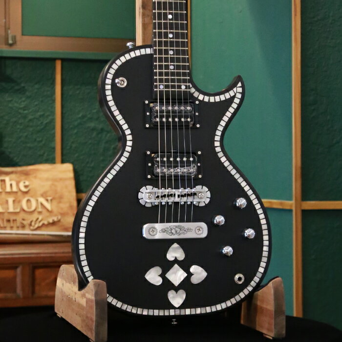 ゼマイティスより、トップにマザー・オブ・パールの象嵌を施したインレイ・フロント・モデル「IFG-AC-24 Heart」が登場しました。 レガシーを継承したデザインに現代的な仕様を融合させたシングル・カッタウェイのオリジナル・ボディー・スタイルで、ボディーとネックに厳選されたアフリカン・マホガニー、フィンガーボードはエボニーを使用しています。 635mmのスケールで、セット・ネック・ジョイント、ミディアム・サイズの24フレット仕様です。 ボディー・トップの外周を沿うように配置されたマザー・オブ・パールのインレイは全部で140枚にも及び、その1枚1枚を手作業にて丁寧に埋め込んでいます。 本物のシェルによる微妙な輝きや色味の違いが美しく、マットなブラック・ボディーに映えるデザインになっています。 ボディー・バックのコントロール・バック・プレートには伝統を示す「A. C. ZEMAITIS SINCE 1955」の文字が刻まれたデザインなどクラシックなルックスが特徴です。 ゼマイティス・オリジナルのアルミ合金を使用したブリッジ＆テイルピースを搭載し、ゼマイティス独自のトーンを生み出す要素となっています。 同様にアルミ合金を用いたヘッドのダイアモンド・エンブレム、トラスロッド・カバー、テイルピースやコントロール&スイッチ・バック・プレートに至るまで彫金を施しています。 ピックアップはブラックのピックアップ・リングを用い、オープン・タイプのDragon Burstハムバッカーを2基搭載しています。 コントロールは定評のあるCTSポットを使用し、各ピックアップ・ヴォリュームと各ピックアップ・トーンのレイアウトです。 スイッチクラフト製の3ウェイ・ピックアップ・セレクター・スイッチを備え、トーンのキャパシターはオレンジ・ドロップを使用しています。 また、スイッチクラフト製のアウトプット・ジャックを使用し、ボディー・トップに配置しています。 さらに信頼性の高いゴトー製のチューナーを使用しています。 フィニッシュはラッカーを使用し、カラーはブラックです。 ハードケースが付属します。 SPEC ■Body : African Mahogany ■Body Top : Flat Shape ■Neck : 1Piece African Mahogany ■Neck Finish: lacquer Hair line ■Neck Joint : Set Neck ■Finger-board : Ebony / 305R ■Nut : Bone 43mm ■Scale : 635mm ■Frets : 24 Medium ■Pickups Neck : Dragon Burst N ■Pickups Bridge : Dragon Burst B ■Controls : 2 x Volume, 2 x Tone , 3Way Pickup Toggle Switch ■Bridge : ZBR-2 ■Tailpiece : ZTP-1 ■Machine Head : Gotoh® SG301-01 Chrom ■Potentiometers : CTS® A 500KΩ ■Capacitors : Orange Drop® (0.022μF) ■Selector Switch : Switchcraft® (SC-1212DX) ■Output Jack : Switchcraft® SC11MONO ■String Gauge : 010, 013, 017, 026, 036, 046 ■Body Finish : Lacquer Hair Line ■Color : BK ■Case : Hardcase